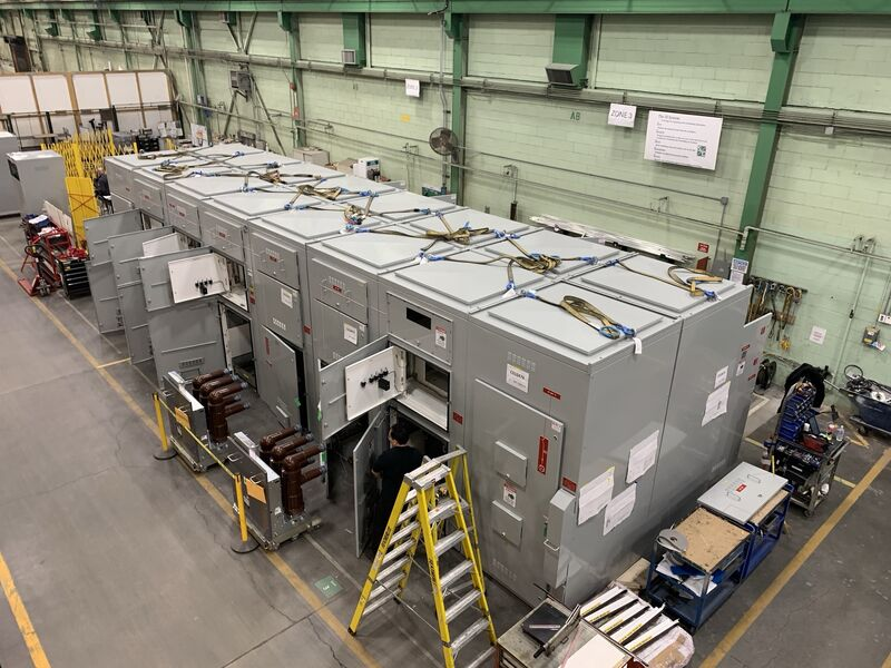 Row of grey S&C switchgear cabinets being assembled on the factory floor