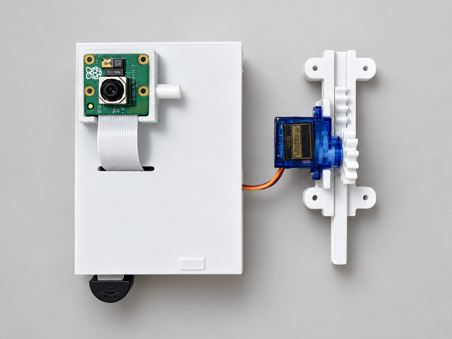 Photograph of the white 3D-printed Resono enclosure with a Raspberry Pi camera module, microphone and a blue servo driving a rack-and-pinion bolt